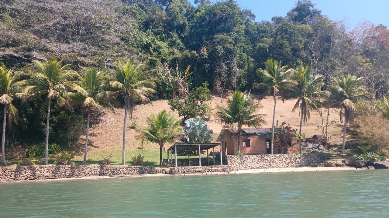 Enseada abrigada com coqueiral e muro de pedra